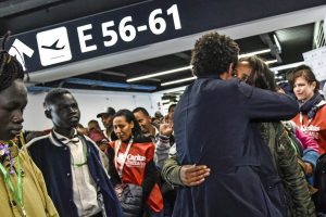 Abbracci in aeroporto per l'arrivo di profughi.