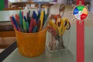 Contenitori con colori e forbici in un'aula scolastica